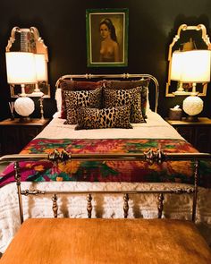 a bedroom with a leopard print comforter on the bed and two nightstands next to it