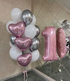 some balloons are arranged in the shape of numbers and one balloon is attached to a wall