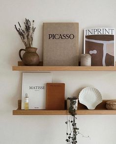 two wooden shelves with books and vases on them