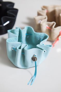 three small pouches are sitting on a table with some string attached to the handles