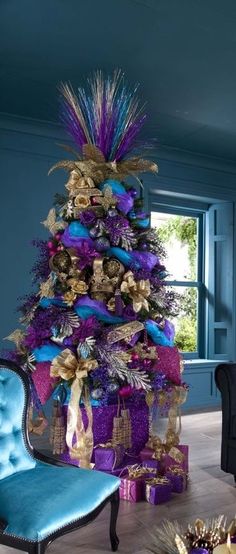 a purple christmas tree with blue and gold decorations