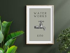 a framed poster hanging on the wall next to a potted plant and water faucet