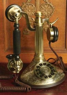 an old fashioned phone sitting on top of a table