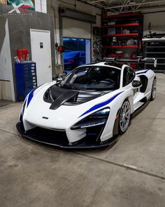 a white and blue sports car parked in a garage
