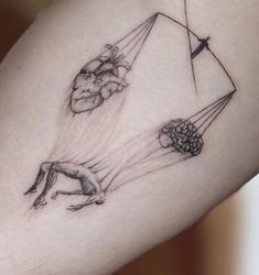 a woman's thigh with some drawings on it and one is holding a kite