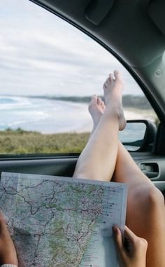 a person sitting in the back seat of a car reading a map