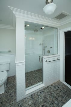 a bathroom with a walk in shower next to a toilet