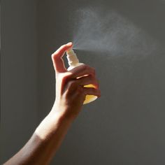 a person spraying something with a spray bottle