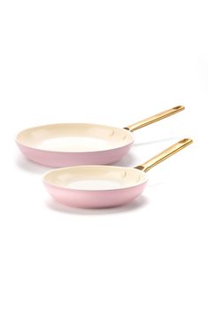 two pink and white pans with gold handles