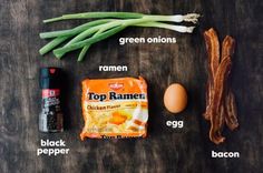 ingredients for an egg and bacon breakfast laid out on a wooden table with green onions