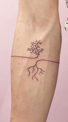 a small tree tattoo on the left leg with roots growing out of it's trunk