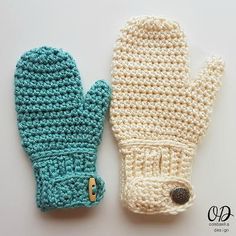 two crocheted mittens sitting next to each other on top of a table