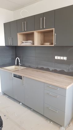 a kitchen with gray cabinets and wooden counter tops in the process of remodeling