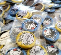 several buttons with cartoon characters on them in plastic bags and some are sitting on the table