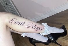 a woman's leg with the words earth angel tattooed on it and her heels