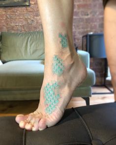 a person's foot with small blue flowers on the top and bottom of it