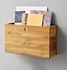 a wooden box with some cards and envelopes in it hanging on the side of a wall