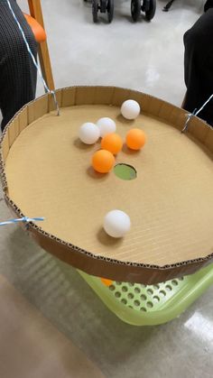 an egg tray with several eggs in it and string attached to the sides, sitting on top of a table
