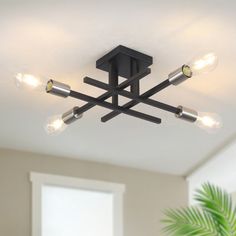 a black ceiling light with four lights on the top and one is turned on to dimmers