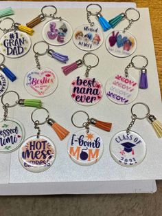 a bunch of key chains that have different designs on them, and the words best mama ever