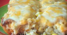 an enchilada with corn and cheese is on a green plate, ready to be eaten