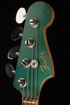 an electric guitar with several different knobs on it's head and neck, against a black background