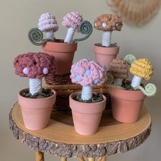 small crocheted flowers sitting in flower pots on a table