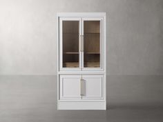 a white cabinet with glass doors on the front and bottom, in an empty room