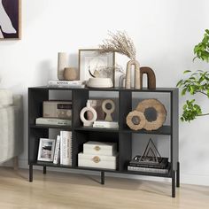 a book shelf with books, vases and other items on it in a living room