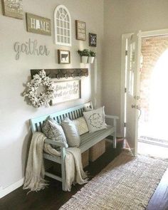 a wooden bench sitting in front of a doorway next to a white wall with pictures on it