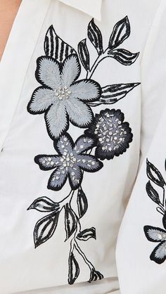 a close up of a white shirt with black flowers on the front and back side