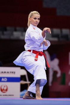 a woman standing on one leg while holding a red belt
