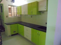 an empty kitchen with green and white cabinets