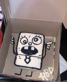 a cake in the shape of a box with an angry face drawn on it's side