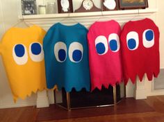 four towels with eyes and mouths hanging on a clothes rack in front of a fireplace