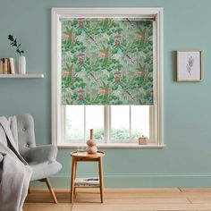 a living room with blue walls and a window covered in green floral wall coverings