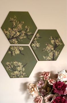 three green hexagons with flowers on the wall next to eachother