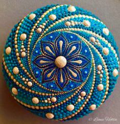 a blue and white beaded box sitting on top of a gray surface with gold dots