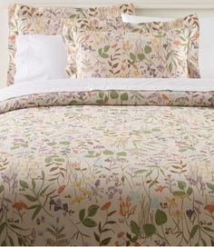 a bed with floral comforter and pillows on it