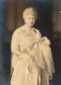 an old black and white photo of a woman holding a baby