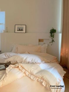 an unmade bed with white sheets and pillows