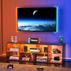 a living room with a large flat screen tv mounted on the wall above it's entertainment center