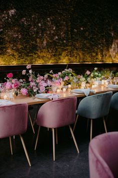 a long table with pink chairs and flowers on it