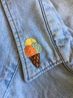 an ice cream cone embroidered on the back of a jean jacket