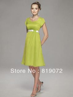 a woman in a green dress posing for the camera with her hands on her hips