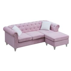 a pink sectional sofa with white pillows