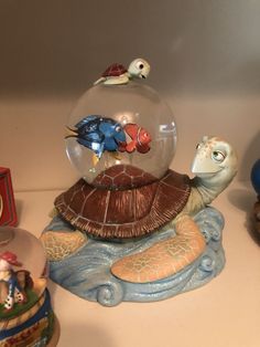 there is a glass ball on top of a turtle and other figurines around it