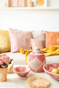 a living room filled with lots of furniture and flowers on top of a white table