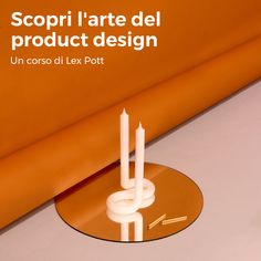 two candles sitting on top of a table next to an orange wall with the words decourrez le design d'objets