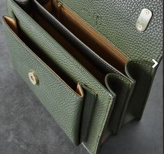 the inside of a green leather purse with two compartments and one open pocket on top